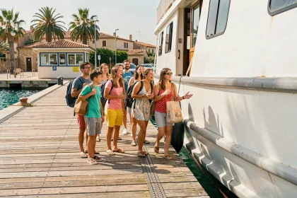 Groupe de familles et amis embarquant sur un ferry blanc pour rejoindre l'île de Porquerolles depuis un port méditerranéen
